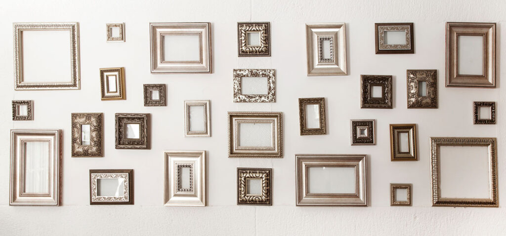 Multiple many blank small picture frames on white wall